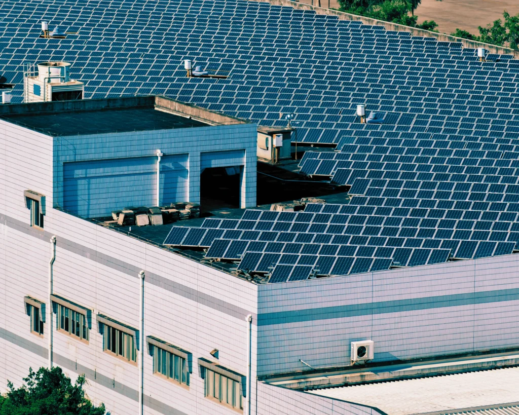 A row of solar panels mounted on a rooftop, harnessing sunlight to generate clean energy for industrial purposes.