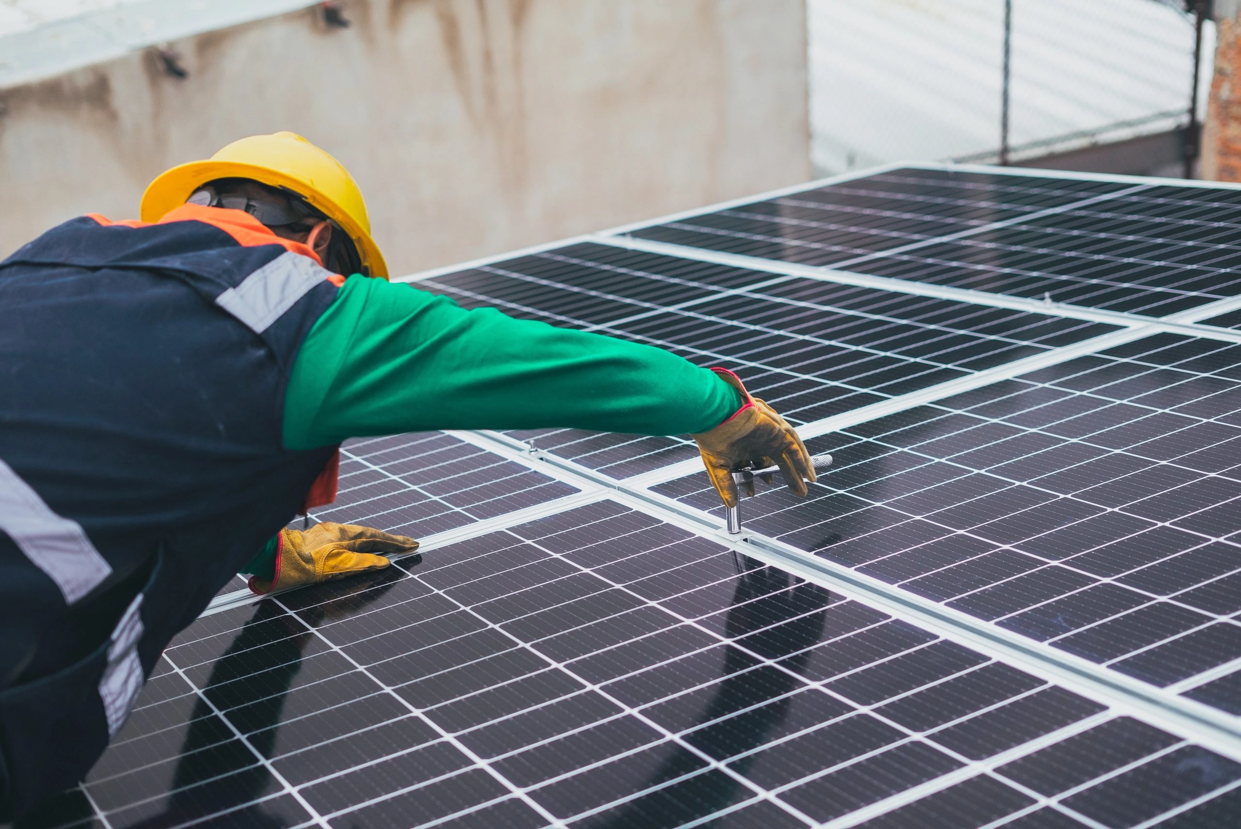 Worker installing solar panels under bright sun